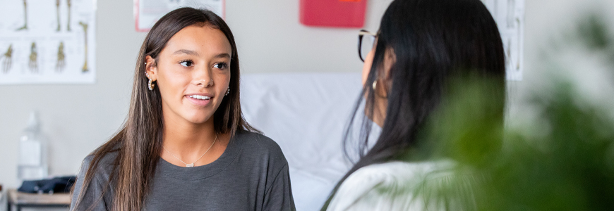 Teenage girl describes her symptoms to care provider