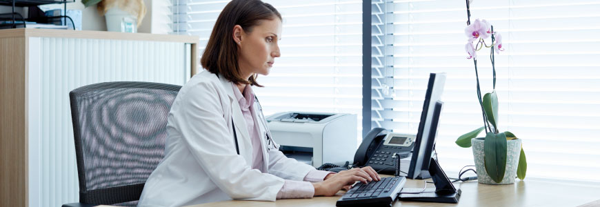 Physician sitting at desk typing
