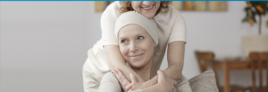 Woman with cancer being hugged by a loved one