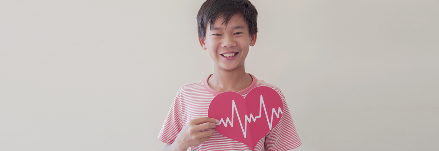 Young Asian boy holding a paper heart