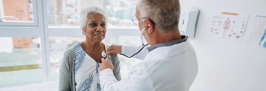 Portrait of a doctor listening to an elderly woman patient's heartbeat