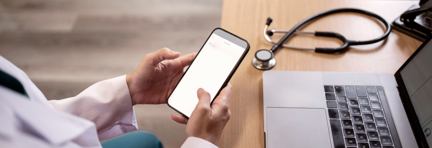 Doctor using a phone and laptop in her office