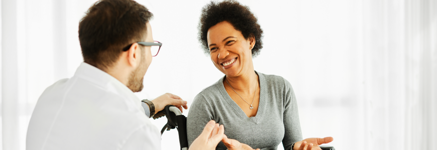 Portrait of a young woman in wheelchair and her doctor at home or in hospital