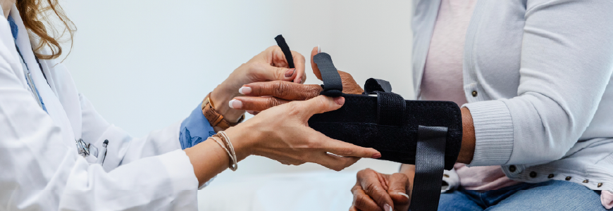 Female orthopedist fits her patient with a wrist splint 