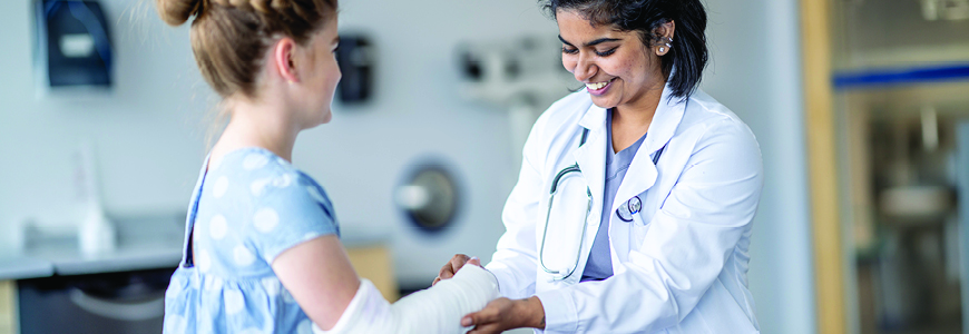 Surgeon evaluating a little girl's broken arm