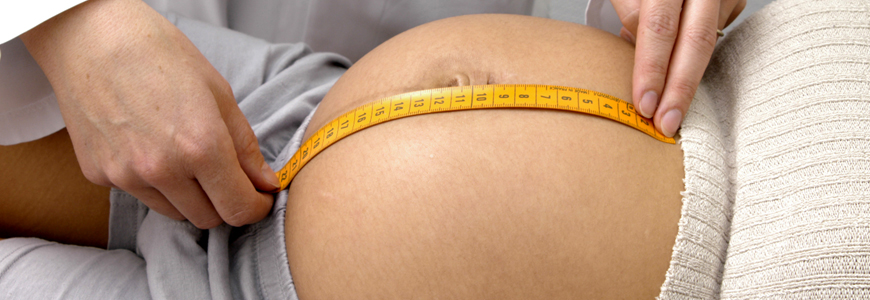 Physician measuring pregnant woman's belly