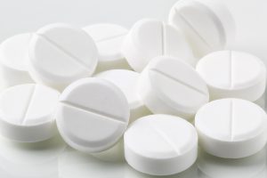 Bunch of white round pills and drugs on white background