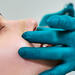 physician examing nose of female patient post surgery