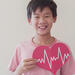 Young Asian boy holding a paper heart