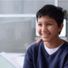 Portrait of smiling Middle Eastern boy visiting doctor in clinic with father supporting
