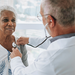 Portrait of a doctor listening to an elderly woman patient's heartbeat