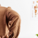 Male orthopedist examining patient's back in clinic