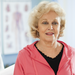 Active senior woman exercising on treadmill with physical therapist.