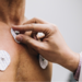 Close-up of human hands putting sensors of electrocardiography on a doctor's office