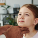 Hands of mature male doctor on neck of cute little patient with soft toy during examination of thyroid at medical consultation in clinics