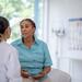 African American woman talking to her medical provider in an exam room