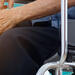 Patient in a wheelchair touching knee