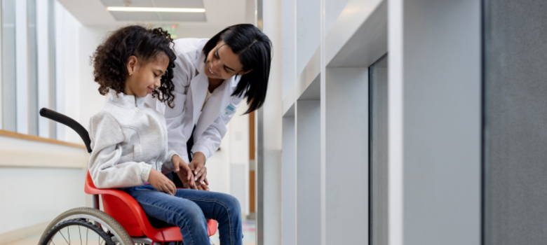Doctor talking to a girl with cerebral palsy in a wheelchair at the hospital